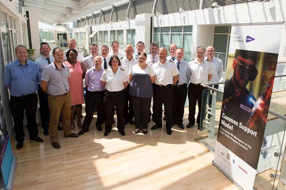 de&s staff stood in front of a sign saying 'Common Support Model'