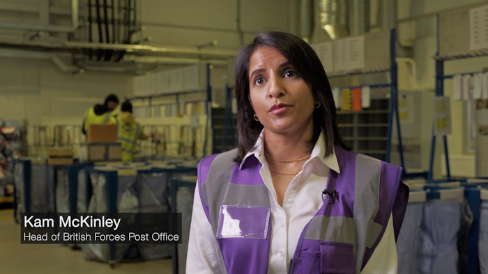 Kam McKinley, Head of British Forces Post Office being interviewed in a post warehouse
