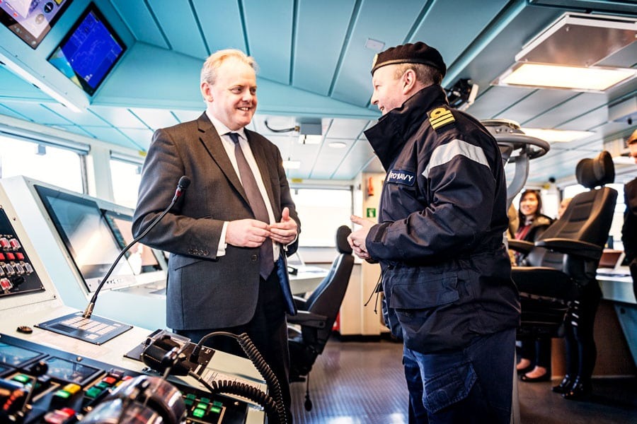 man in a suit interviews a navy officer
