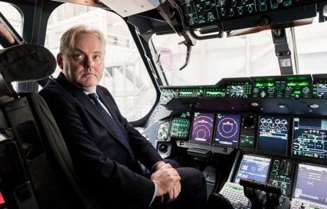 A male government minister in a suit sat in a plane cockpit