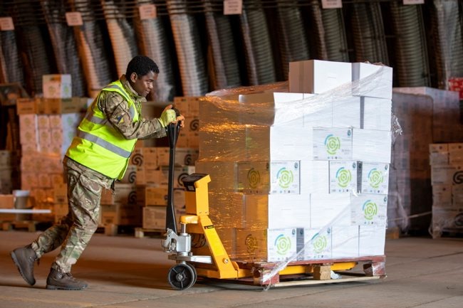 Image shows a member of 4 Regiment, Royal Logistic Corps at work within the National Hub offloading inventory.