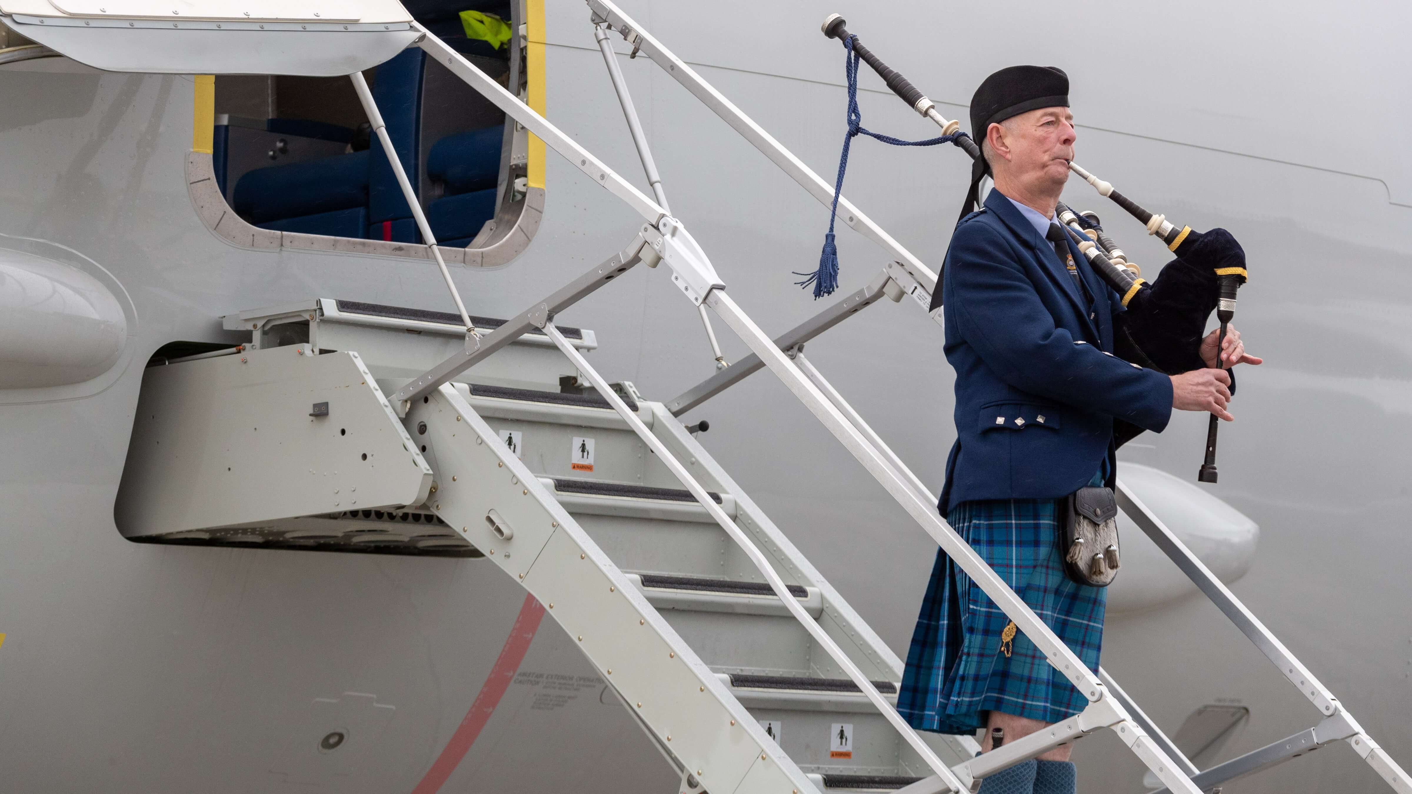 A bagpiper plays after ZP802, the City of Elgin, touches down at RAF Lossiemouth for the first time