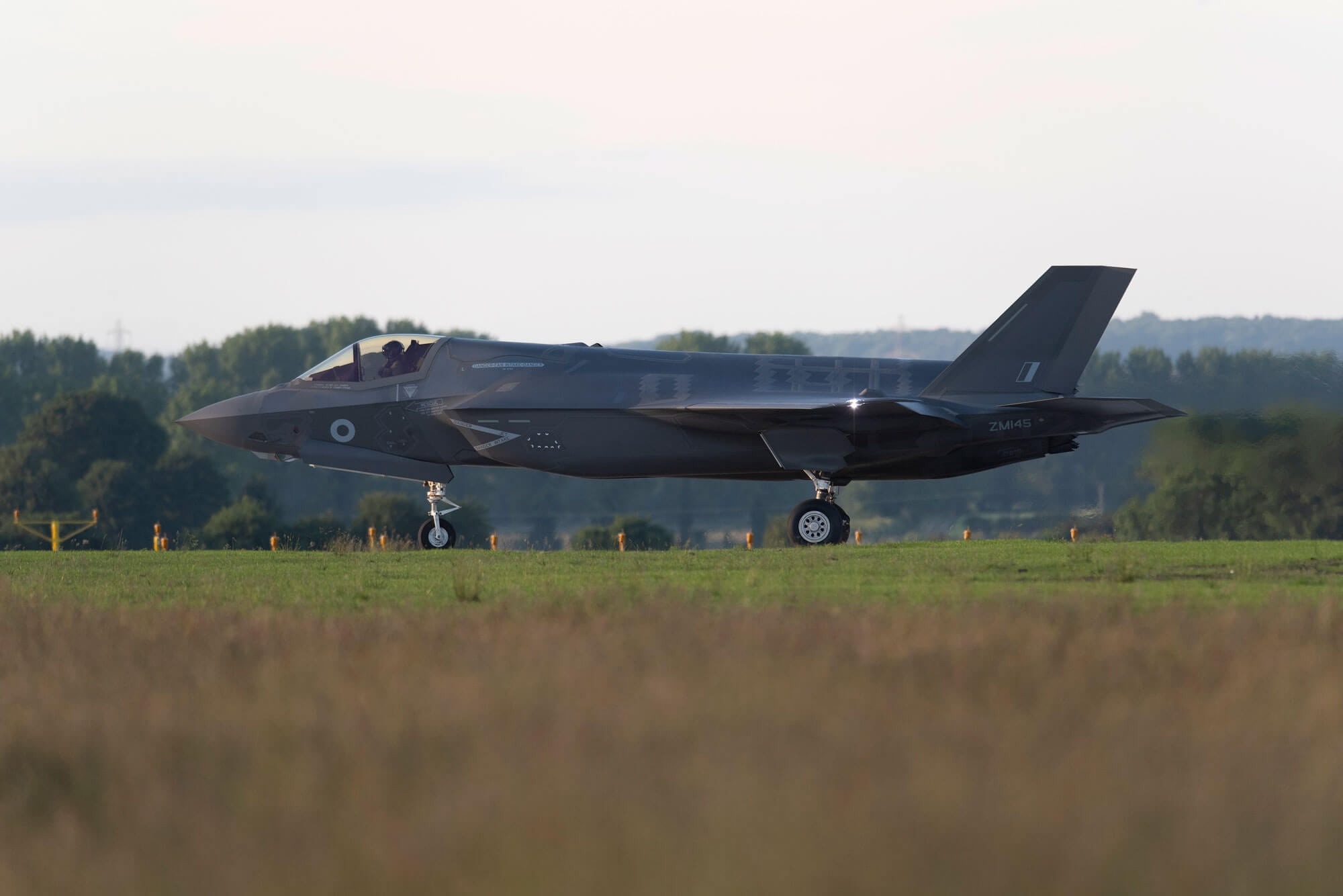 large grey fighter lands on runway