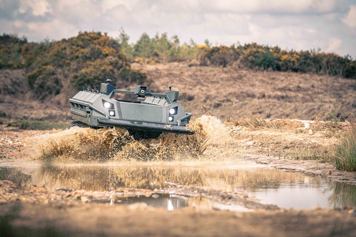 Six-wheel autonomous vehicle driving through deep muddy puddle