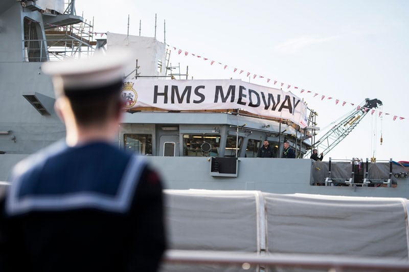 A grey navy ship carrying a banner with HMS Medway written on it