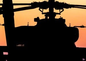 silhouette of apache military helicopter at sunset