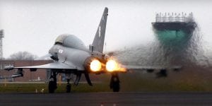 fighter jet with flames coming from its thrusters