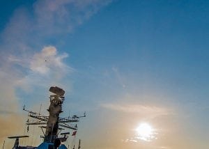 A missile arcs into the air from the deck of a navy ship