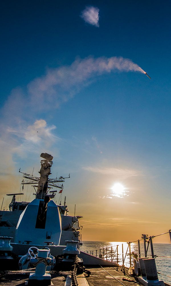 A missile arcs into the air from the deck of a navy ship