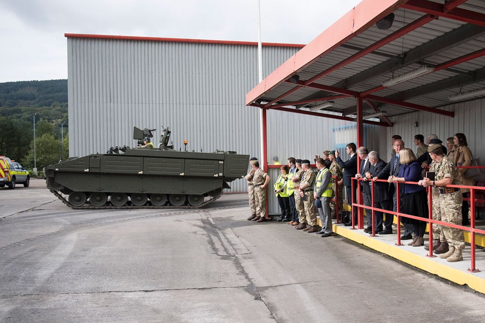 A female government minister being shown an armoured vehicle