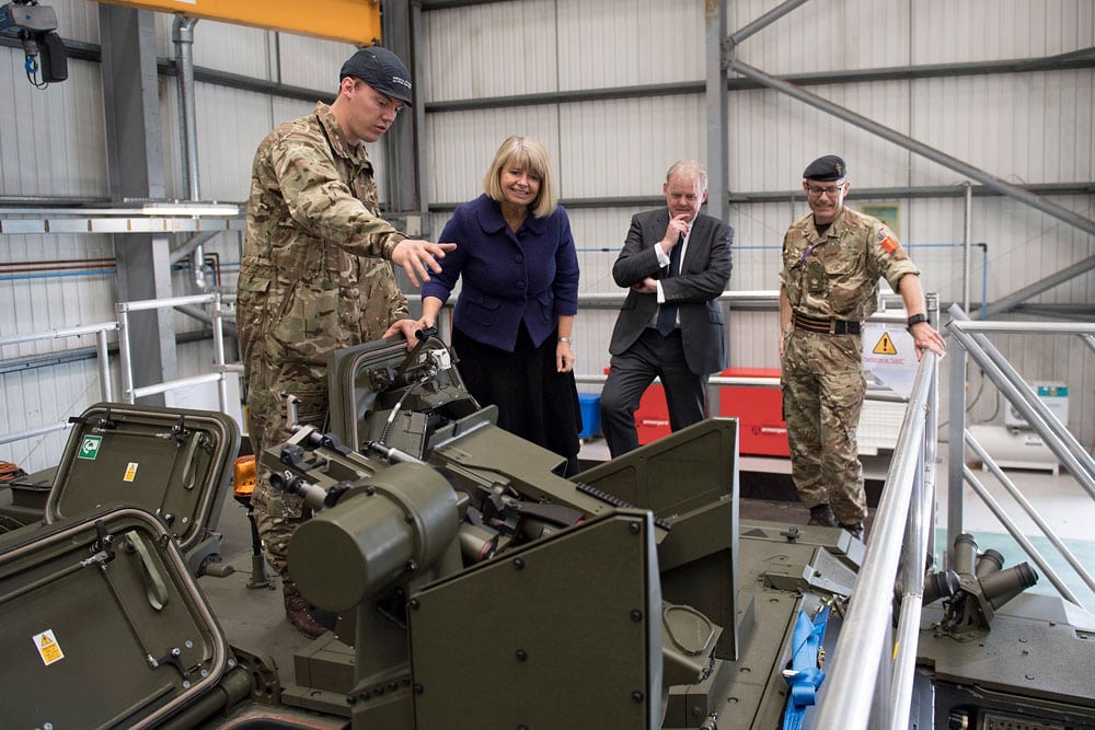 A female government minister being shown an armoured vehicle