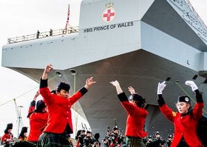 Scottish dancers perform in front of the navy aircraft carrier