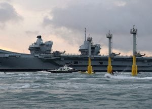 A large grey aircraft carrier at sea