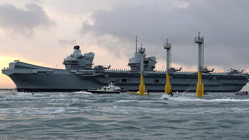 A large grey aircraft carrier at sea