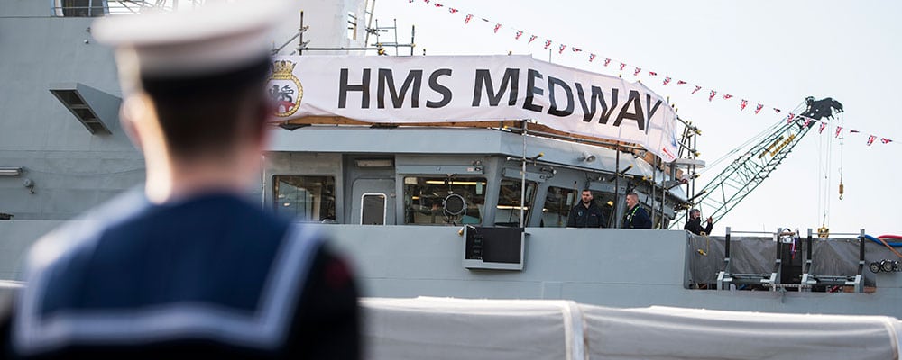 Navy ship covered in banner saying "HMS Medway"