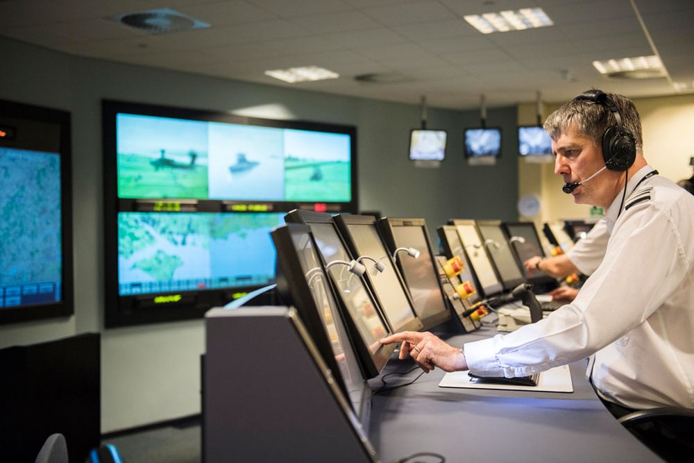 A military man views data on a number of screens in a control centre