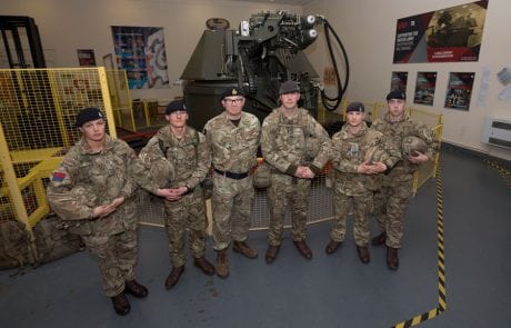 soldiers stood in front of tank turret simulator