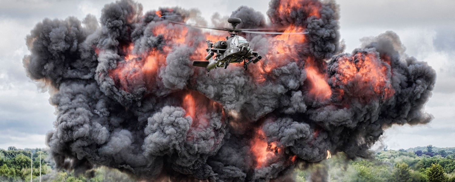 A helicopter flies through an explosion