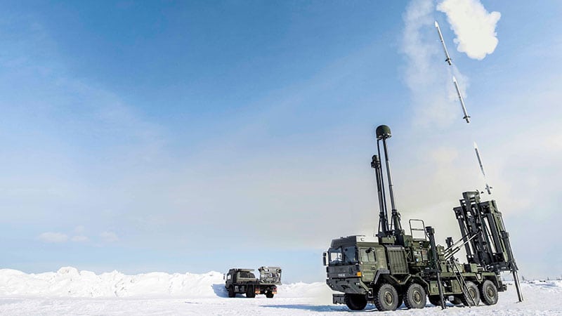 A military vehicle fires a rocket in a snowy environment