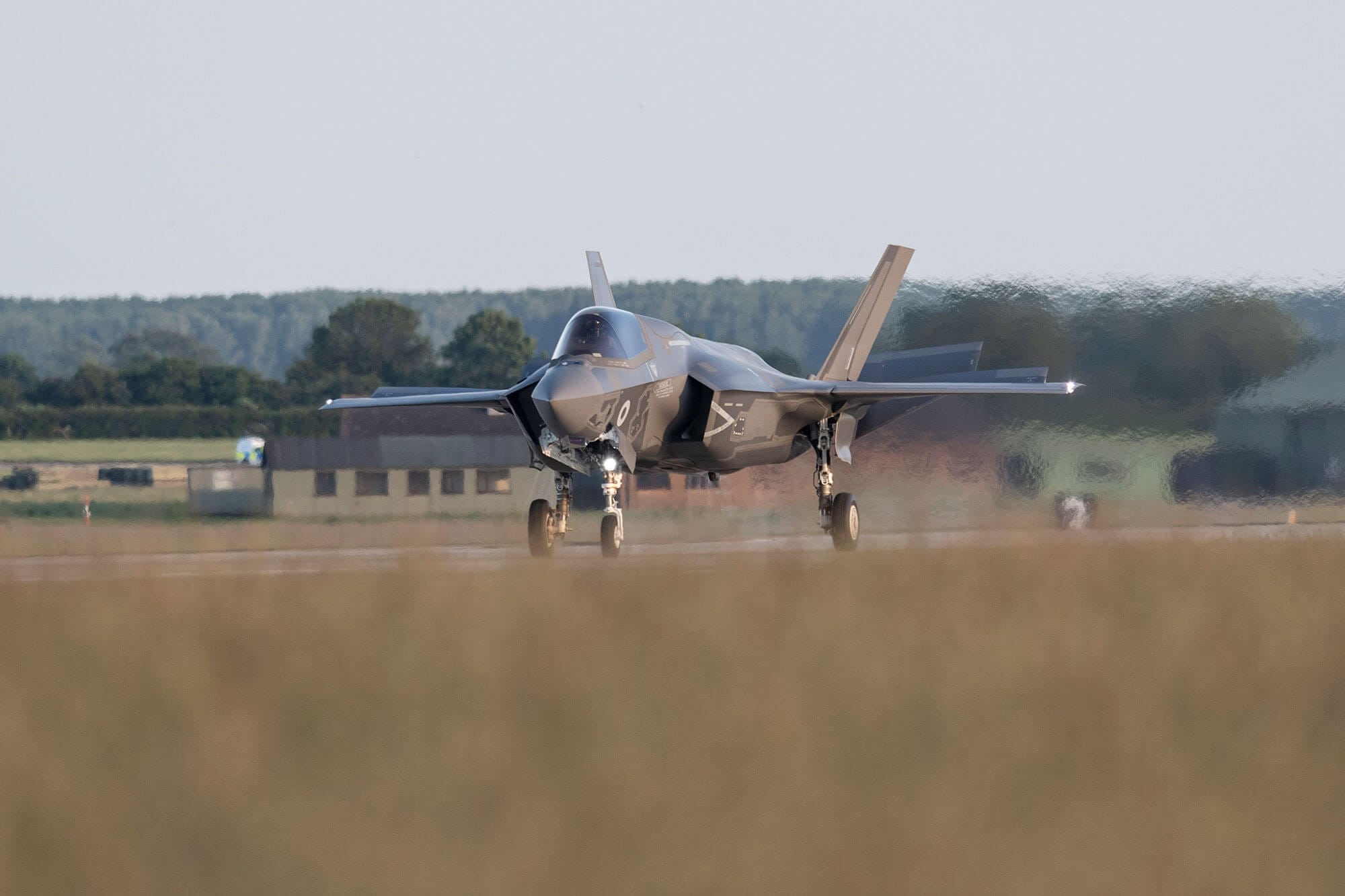 large grey fighter lands on runway