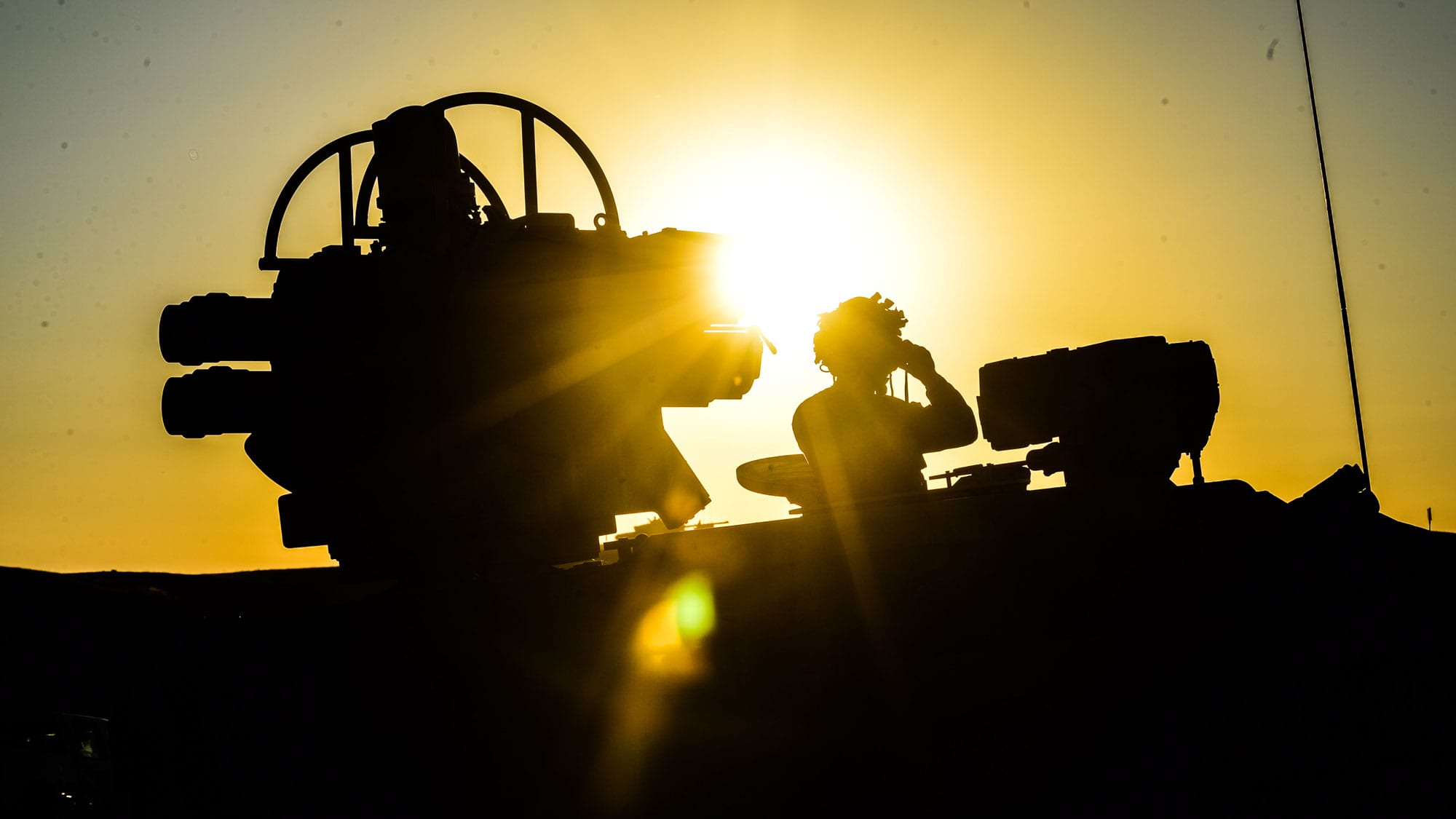 A rocket launcher silhouetted against the sun