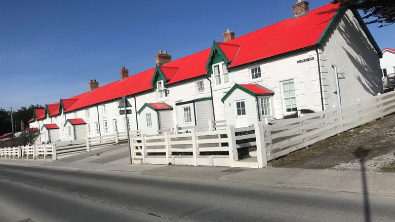A row of white houses with red roofs