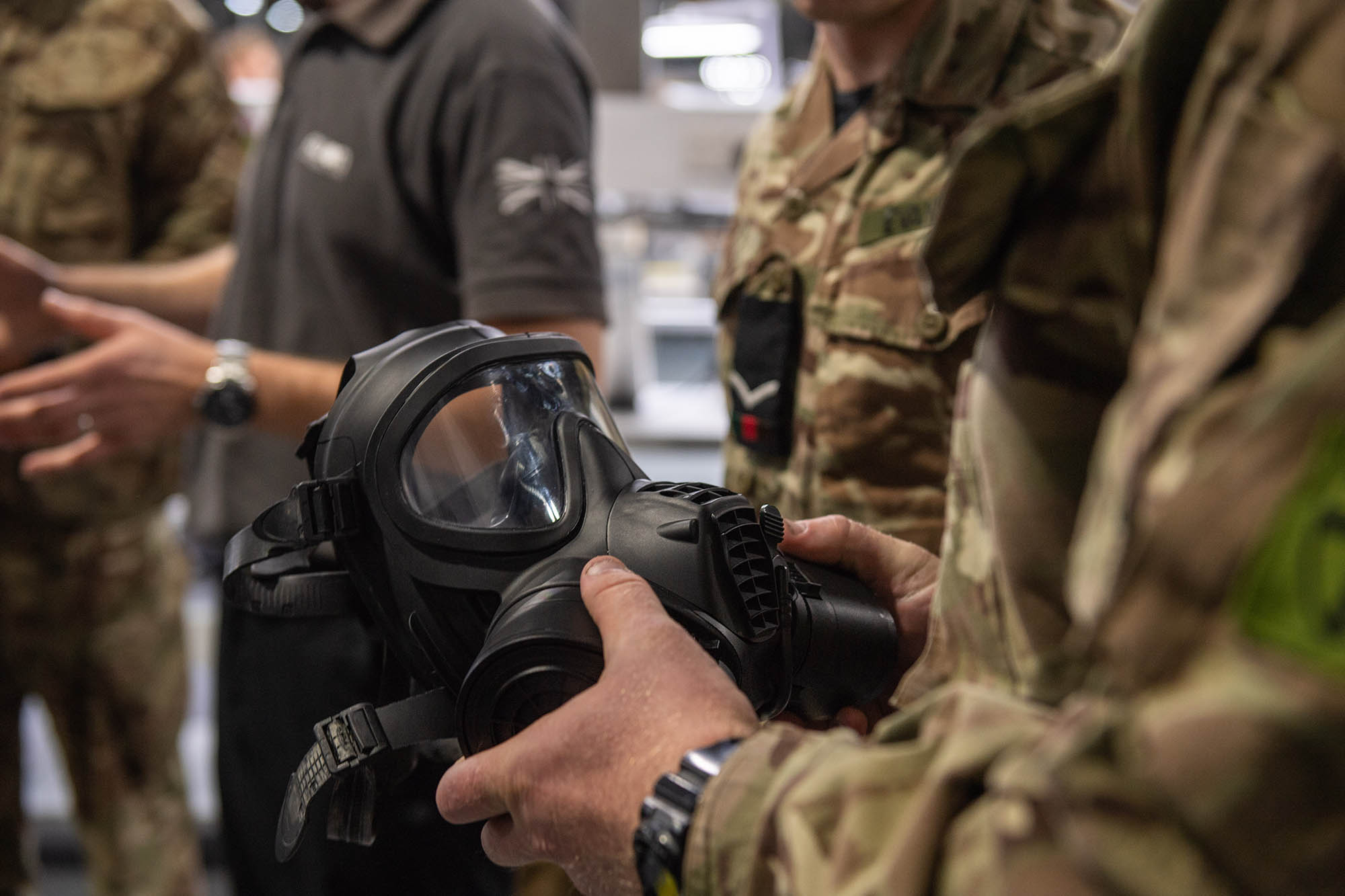 Solider holding a black gas mask