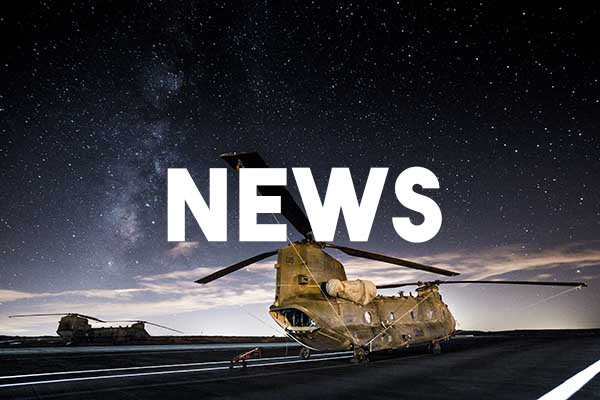 A camouflaged cargo helicopter parked on a runway, with the night sky above it. The word 'NEWS' has been superimposed on top of it.