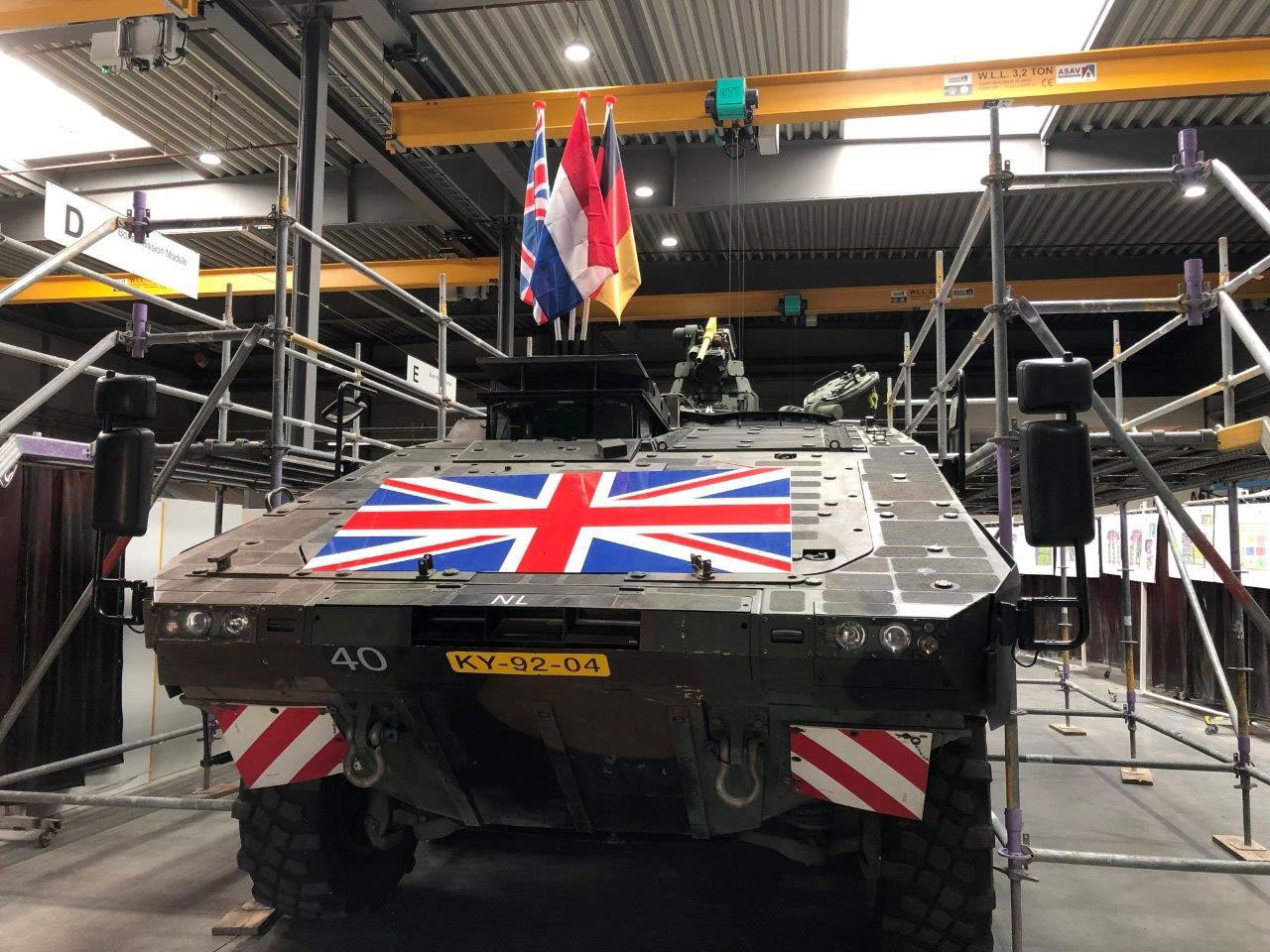 A tank-like armoured vehicle draped in a Union Jack flag