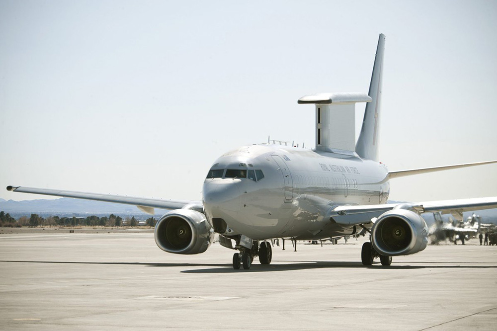 A large grey plane with a large radar on its top