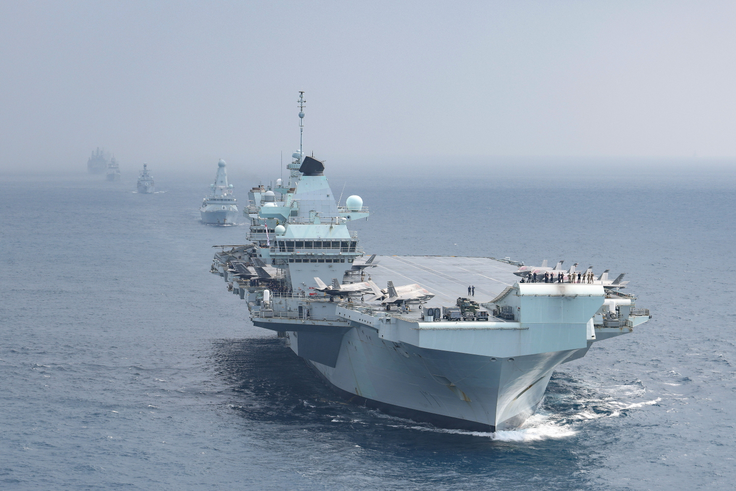 HMS Queen Elizabeth with HMS Defender sailing behind