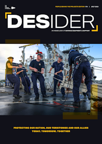 July 2023 Desider front cover showing sailors using ropes to drag a large piece of equipment across the deck of a ship