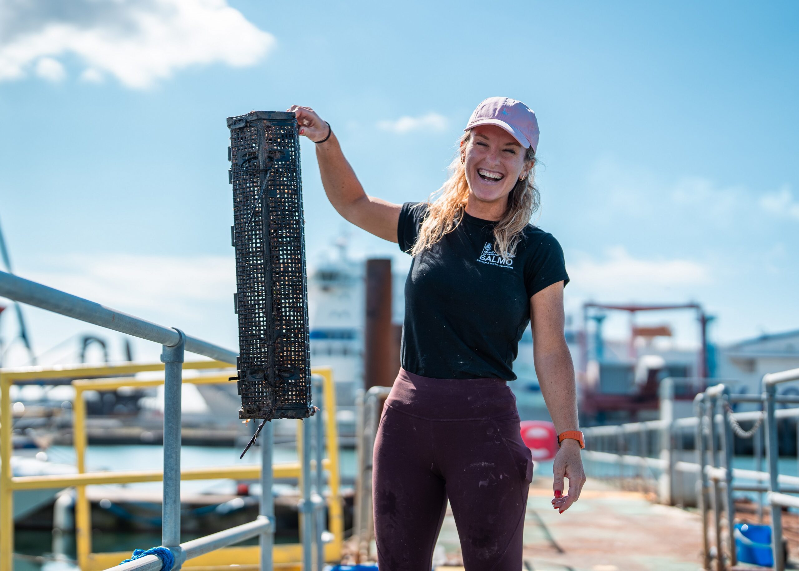 Harriet Rushton from the DE&S SALMO Wrecks team holding up an oyster cage