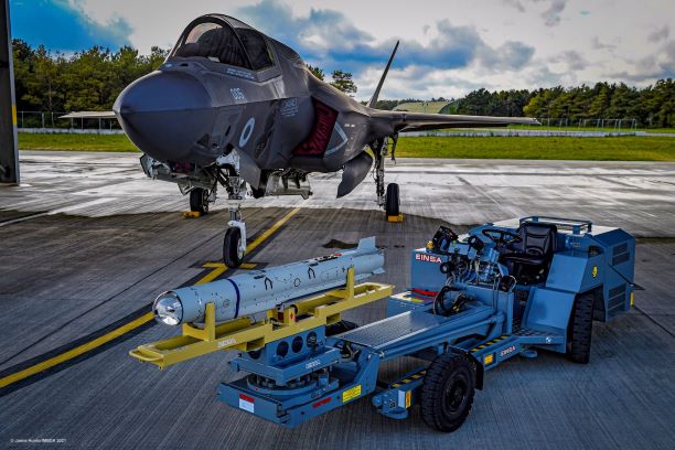 A SPEAR missile in front of an F-35B fighter jet.