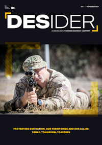 Desider magazine front cover showing a soldier lying on the ground holding rifle to his shoulder and looking through the sights facing towards the camera.