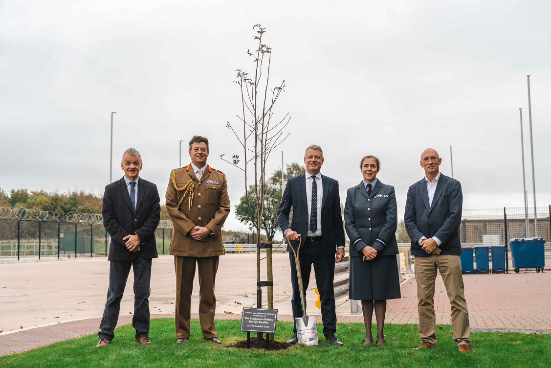 A group of people standing by a newly planted tree